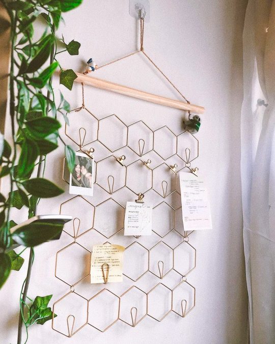 a honeycomb memo board with pinned pictures and notes