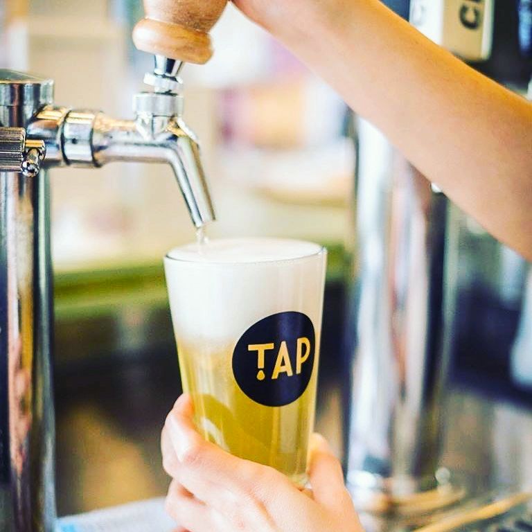 a person pulling a pint of beer at TAP Craft Beer Bar