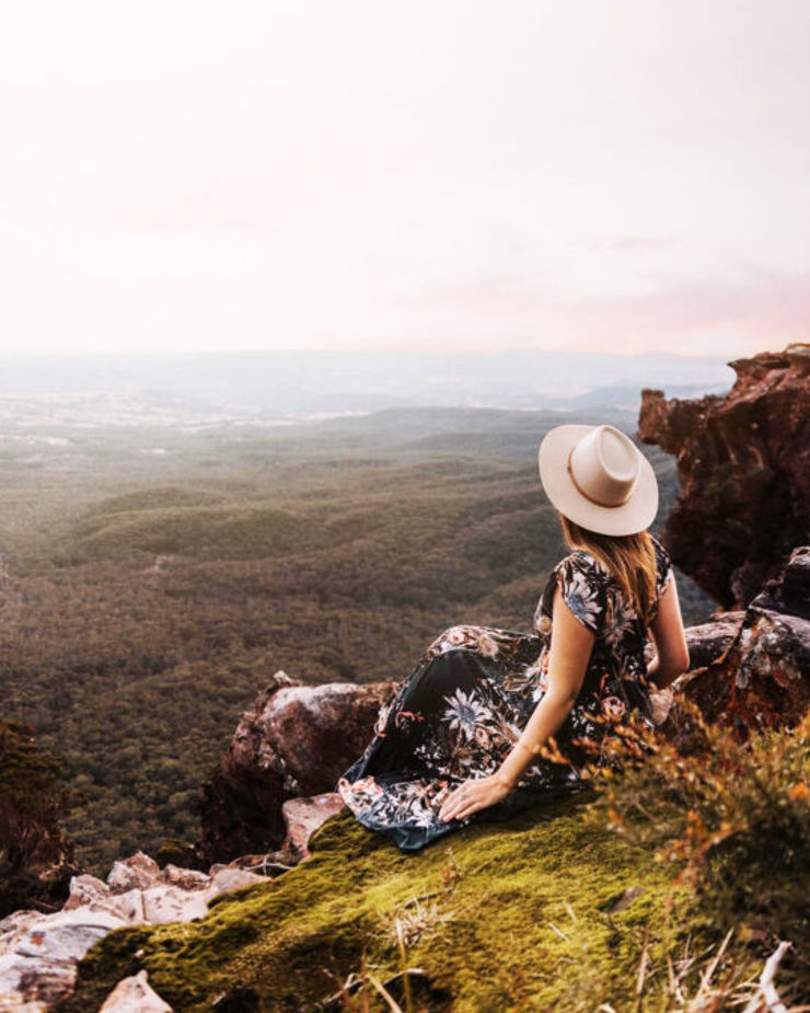 a woman enjoying a view of the valley from the summit of Blue Mountains, Sydney