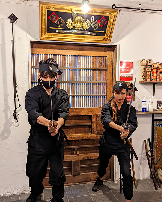 a man and a woman dressed in a Ninja outfit at the Ninja Café