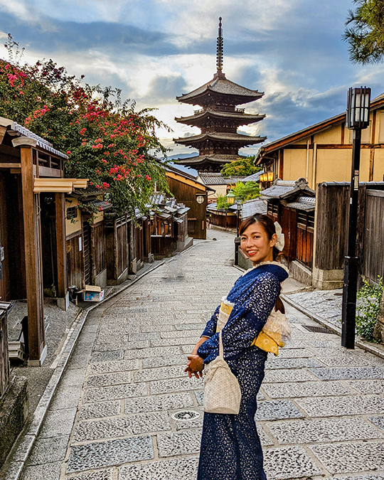 a woman in a traditional Japanese dress posing for a photo at the Yasaka Pagoda