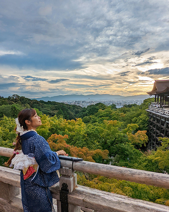 a woman enjoying the beautiful sunset over a calm ocean at Kiyomizudera