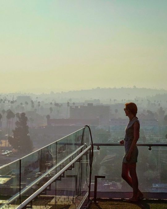 a woman on a balcony at the W Hollywood, gazing at the cityscape below