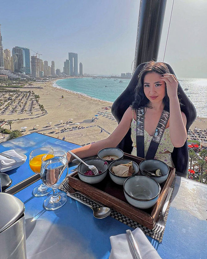 a diner enjoying a meal while suspended in the air at Dinner in the Sky, United Arab Emirates