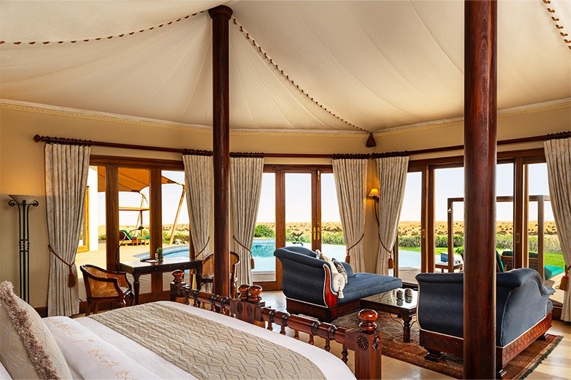 view from within the hotel room with bed and sofa at Al Maha Desert Resort and Spa