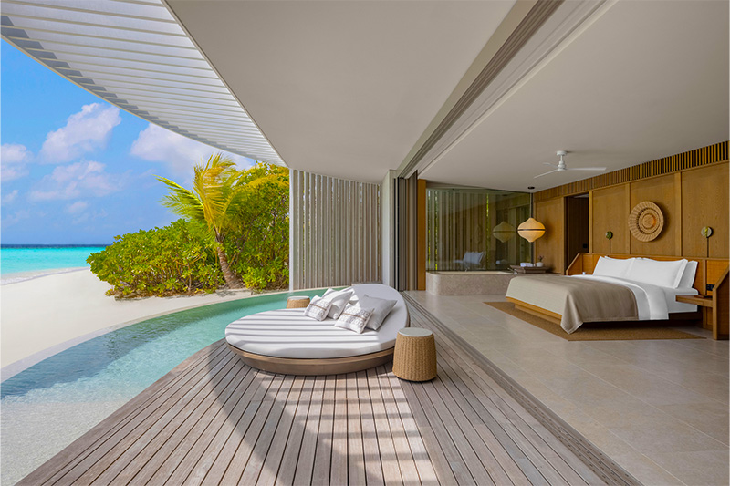 bright bedroom with a pool and ocean view