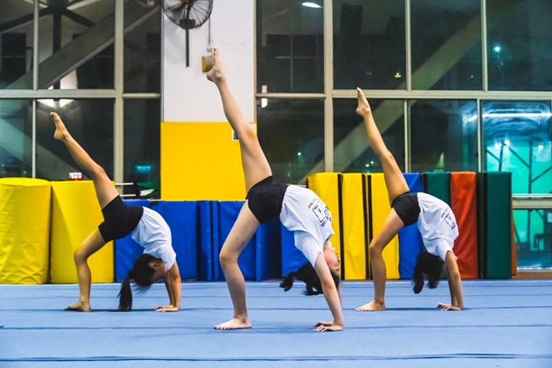 3 girls doing gymnastics at a gym